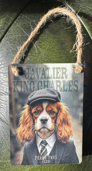 Decorative sign with a Cavalier King Charles dog wearing a hat and suit.